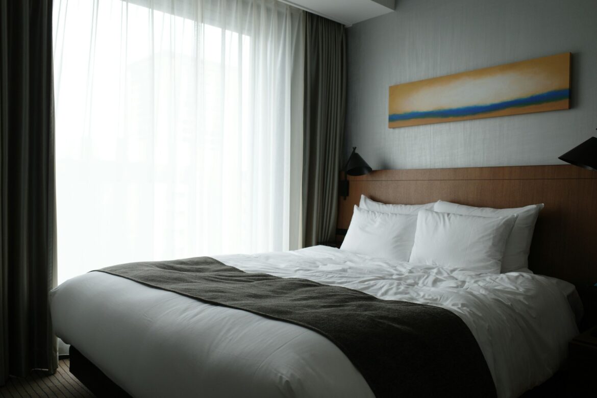 a bedroom with a large bed and a painting on the wall