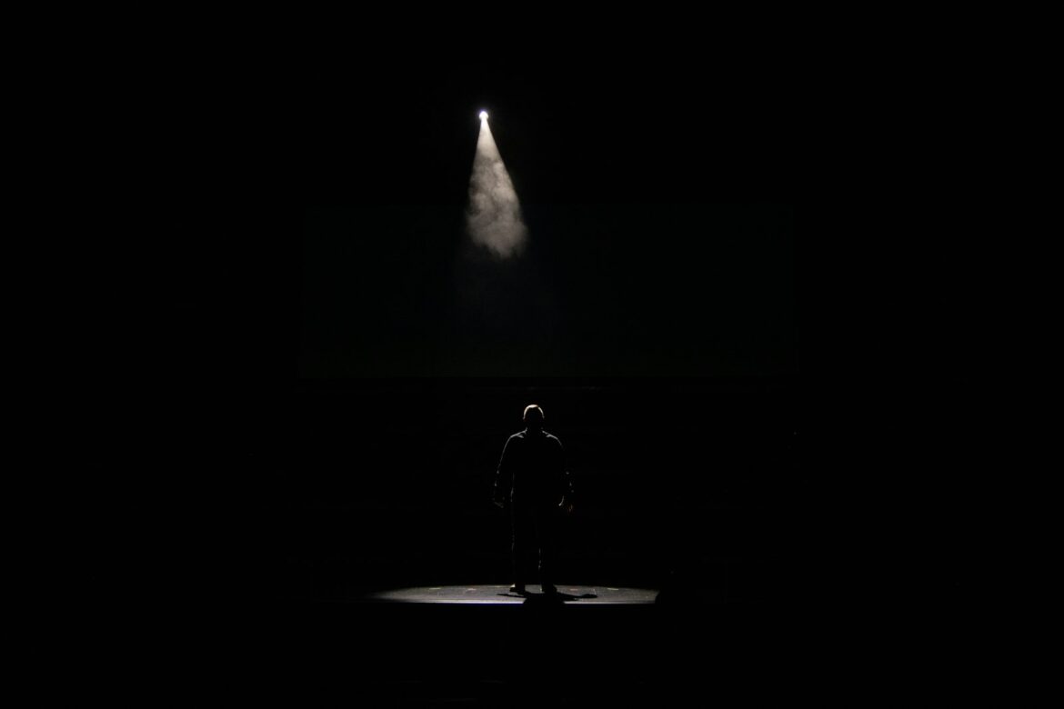 Zanger op een podium in het licht van de spots