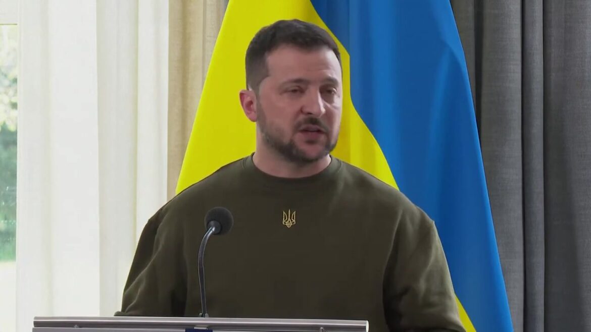 Volodymyr Zelensky spreekt achter een katheder met de Oekraïense vlag